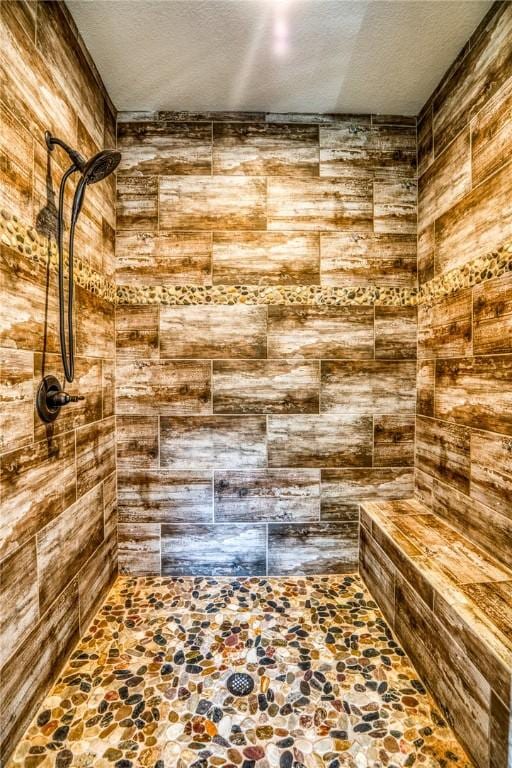 bathroom featuring a tile shower and a textured ceiling