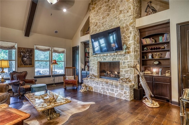 living room with ceiling fan, beam ceiling, hardwood / wood-style flooring, high vaulted ceiling, and a fireplace