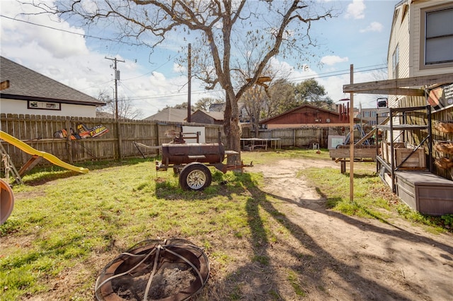 view of yard with a playground, a trampoline, and a fire pit