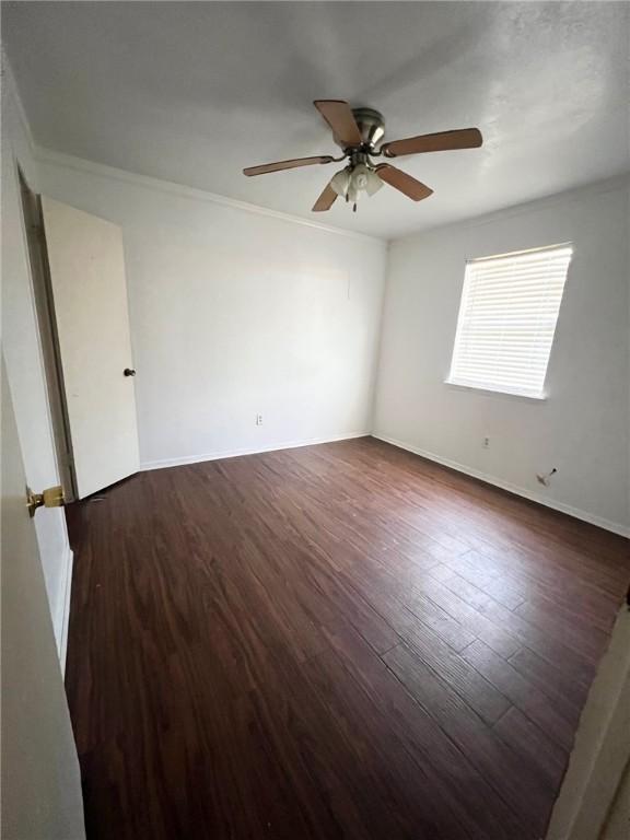 unfurnished room featuring ceiling fan, crown molding, baseboards, and wood finished floors