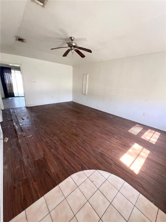 unfurnished living room featuring ceiling fan, visible vents, and wood finished floors