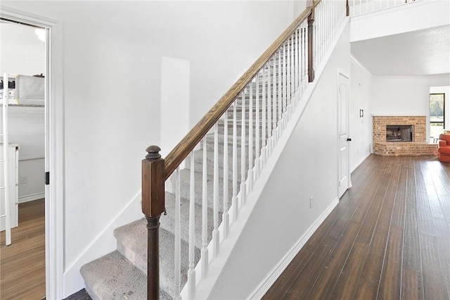 staircase featuring a fireplace and hardwood / wood-style flooring