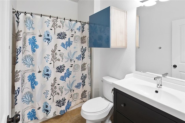 bathroom featuring tile patterned flooring, vanity, toilet, and walk in shower