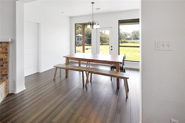 dining area with a chandelier and dark wood-type flooring