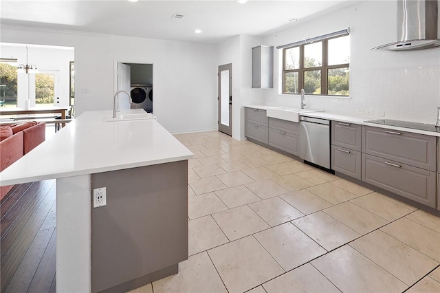 kitchen featuring dishwasher, sink, an island with sink, and a wealth of natural light