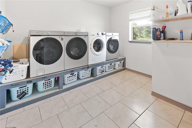 washroom with light tile patterned floors and washing machine and dryer