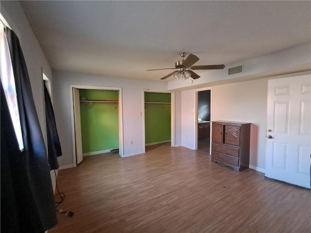 1202 Cheyenne Dr, Brenham, TX 77833 - unfurnished bedroom featuring multiple closets, wood finished floors, and ceiling fan