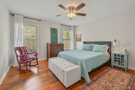 bedroom with hardwood / wood-style floors, multiple windows, and ceiling fan