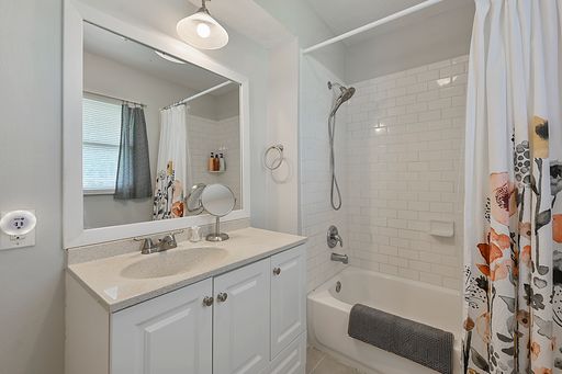 bathroom with shower / bathtub combination with curtain and vanity