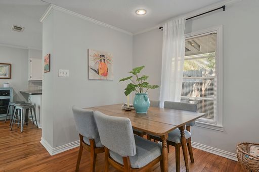 dining area with crown molding and hardwood / wood-style floors