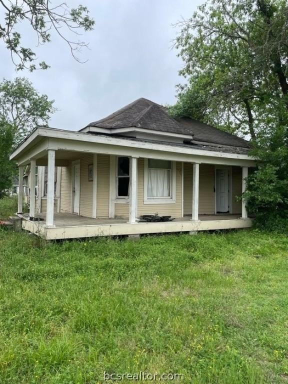 rear view of property with a lawn and covered porch