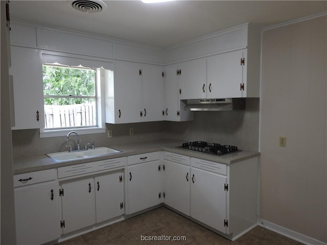 kitchen featuring backsplash, stainless steel gas stovetop, white cabinetry, and sink