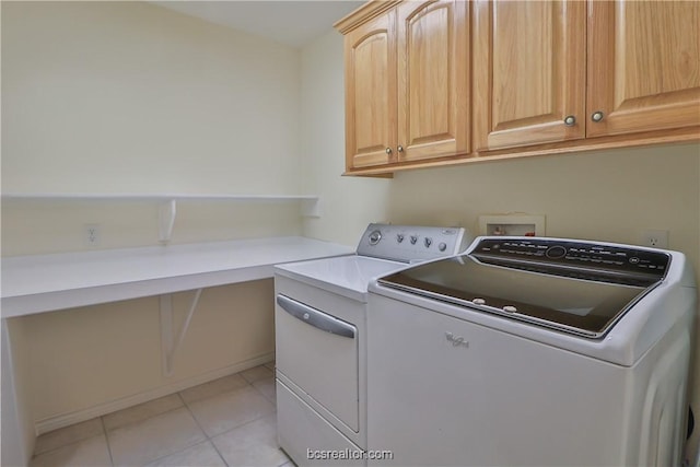 laundry room featuring washer and dryer, cabinets, and light tile patterned floors