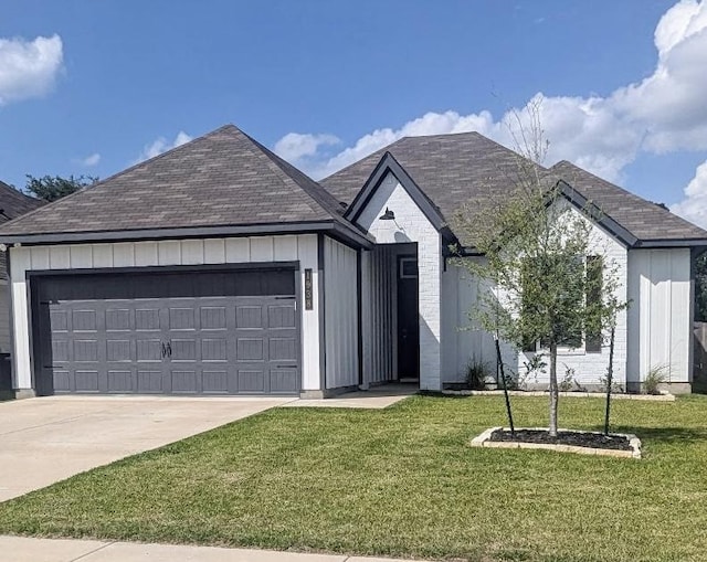 1938 Chief St, Bryan, TX 77807 - view of front of property with an attached garage, driveway, a front yard, and board and batten siding