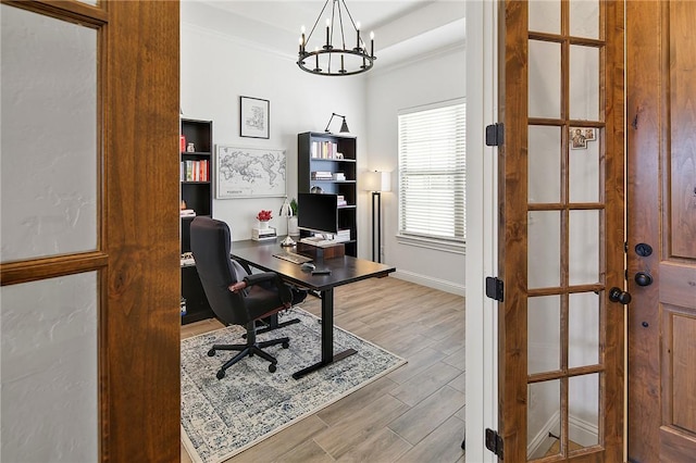 home office with a notable chandelier, baseboards, wood finished floors, and crown molding