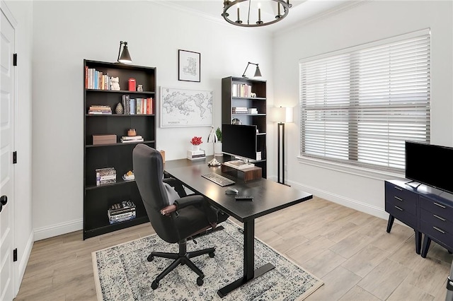 office area featuring light wood finished floors, baseboards, and crown molding