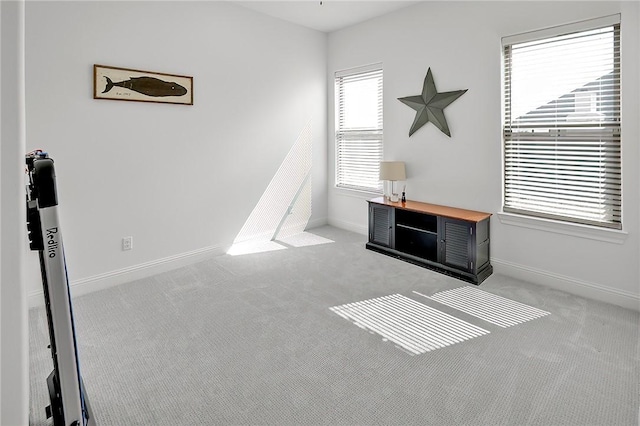 interior space featuring light carpet and baseboards