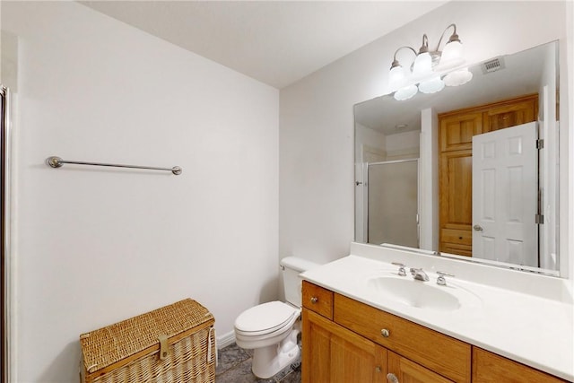 bathroom with vanity, toilet, a shower with shower door, and a chandelier