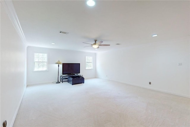 unfurnished living room with light carpet, a healthy amount of sunlight, ceiling fan, and crown molding