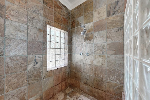 bathroom featuring a tile shower, crown molding, and plenty of natural light