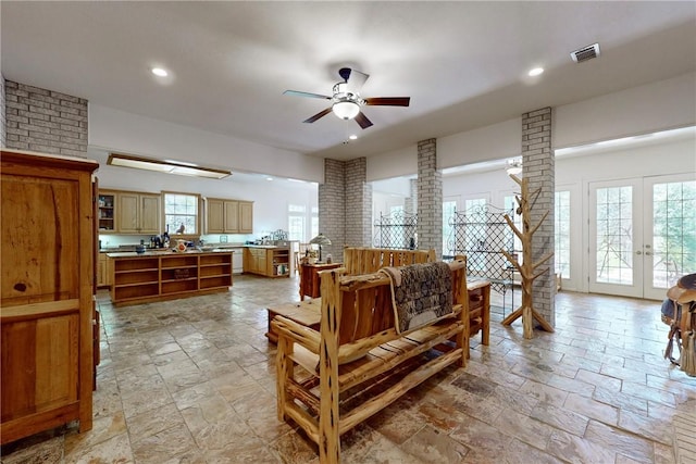 living room featuring french doors, ornate columns, and ceiling fan