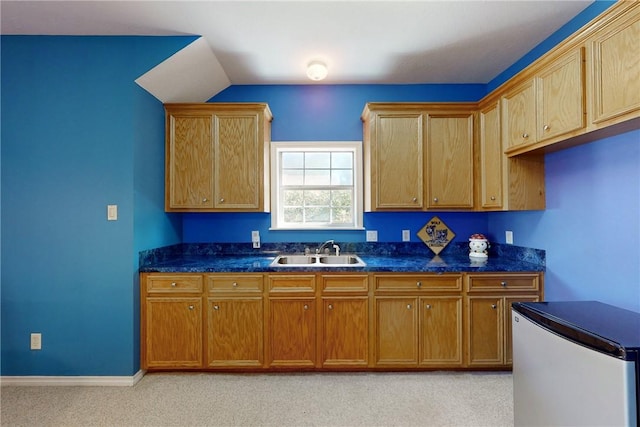 kitchen featuring light colored carpet, fridge, and sink