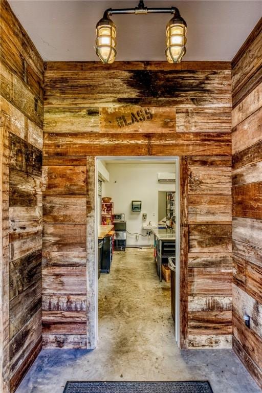 402 Ross St, Brenham, TX 77833 - corridor with concrete flooring, wooden walls, and a wall mounted air conditioner