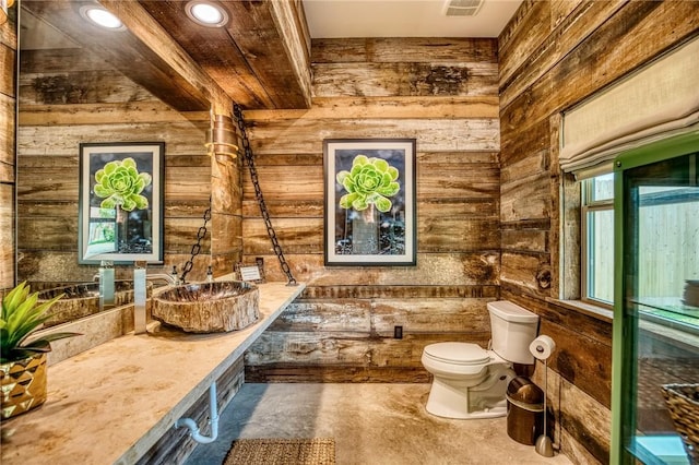 402 Ross St, Brenham, TX 77833 - bathroom with wood walls, toilet, and vanity