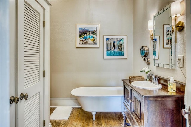 402 Ross St, Brenham, TX 77833 - full bath featuring a soaking tub, vanity, wood finished floors, and baseboards