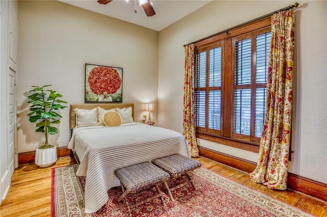 402 Ross St, Brenham, TX 77833 - bedroom featuring multiple windows, baseboards, wood finished floors, and a ceiling fan