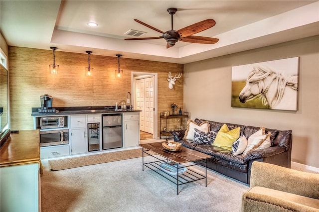 402 Ross St, Brenham, TX 77833 - carpeted living area with a tray ceiling, ceiling fan, bar with sink, and recessed lighting