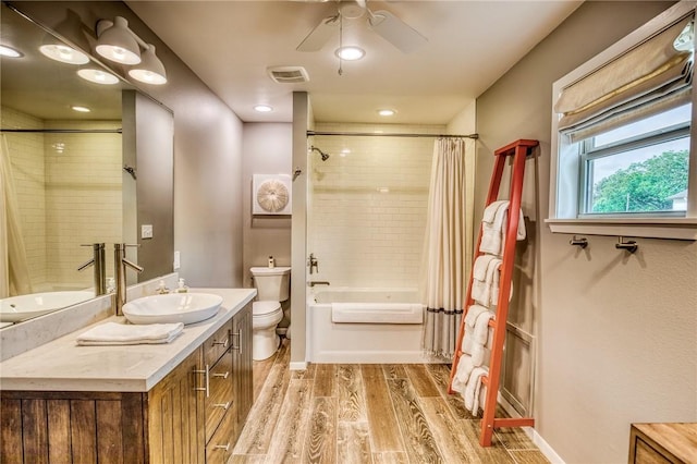 402 Ross St, Brenham, TX 77833 - full bathroom featuring toilet, shower / bath combo, vanity, wood finished floors, and ceiling fan