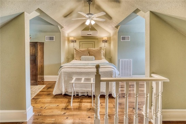 402 Ross St, Brenham, TX 77833 - bedroom featuring wood finished floors, lofted ceiling, baseboards, a textured wall, and a textured ceiling