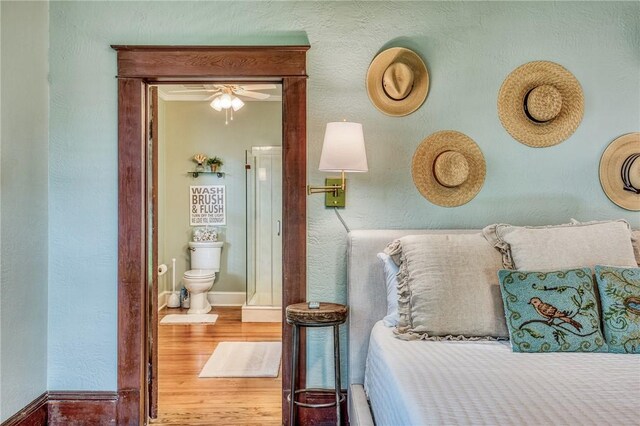 402 Ross St, Brenham, TX 77833 - bedroom featuring wood finished floors, baseboards, and ensuite bathroom