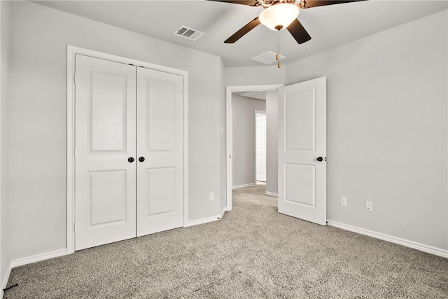 unfurnished bedroom featuring ceiling fan, light colored carpet, and a closet