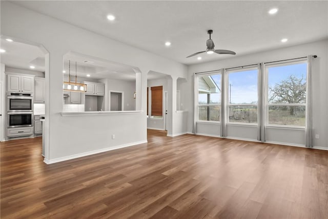 unfurnished living room with ceiling fan and dark hardwood / wood-style floors