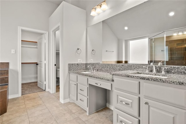 bathroom with toilet, walk in shower, tile patterned flooring, lofted ceiling, and vanity