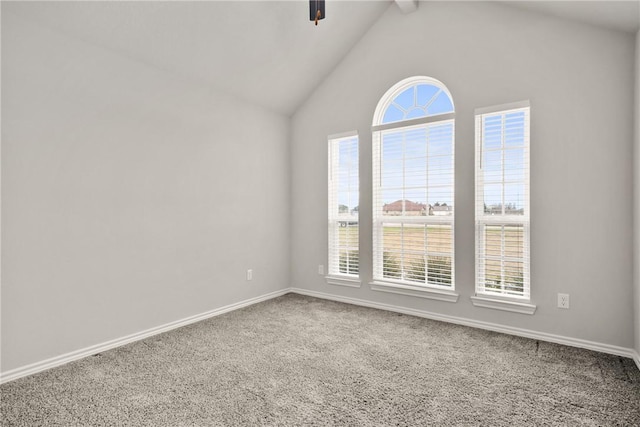 carpeted spare room featuring ceiling fan, vaulted ceiling with beams, and a wealth of natural light