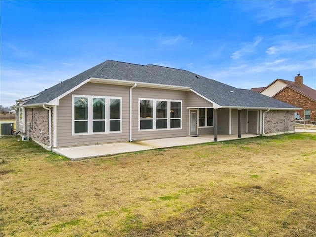 rear view of property with a patio area, a lawn, and central AC