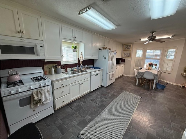 kitchen featuring ceiling fan, sink, a textured ceiling, white appliances, and white cabinets