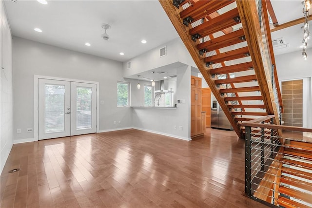 213 N Houston Ave, Bryan, TX 77803 - unfurnished living room featuring stairs, wood finished floors, french doors, and recessed lighting