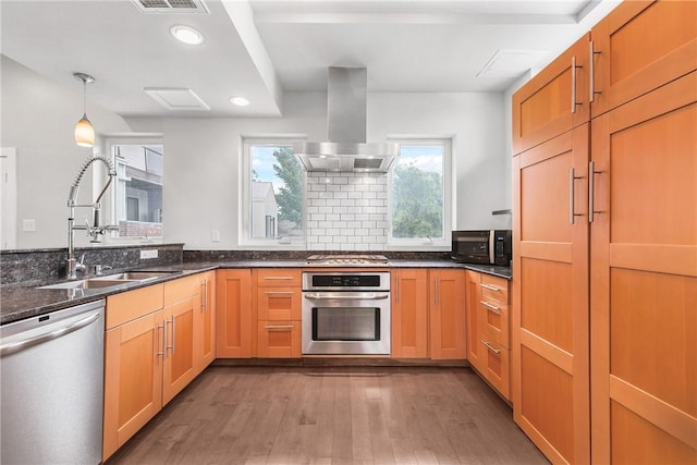 213 N Houston Ave, Bryan, TX 77803 - kitchen featuring appliances with stainless steel finishes, island exhaust hood, wood finished floors, recessed lighting, and dark stone countertops