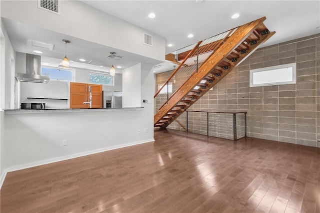 213 N Houston Ave, Bryan, TX 77803 - unfurnished living room featuring wood finished floors, recessed lighting, stairway, and tile walls