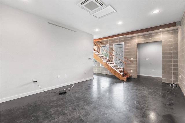 213 N Houston Ave, Bryan, TX 77803 - unfurnished living room featuring tile walls, attic access, recessed lighting, finished concrete floors, and stairs