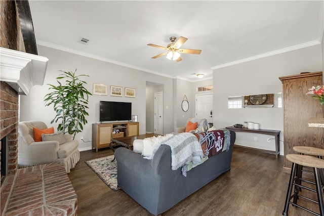 living area featuring crown molding, a fireplace, visible vents, and dark wood-style flooring