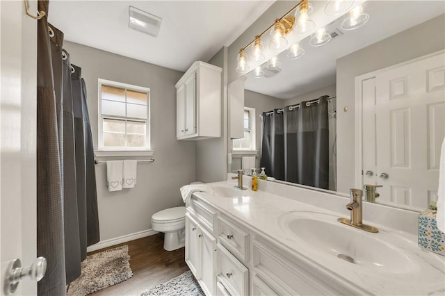 full bath with wood finished floors, a sink, toilet, and baseboards