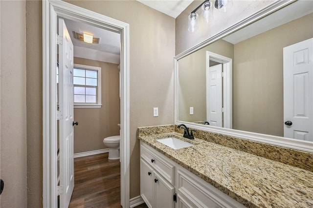 bathroom with vanity, wood-type flooring, and toilet