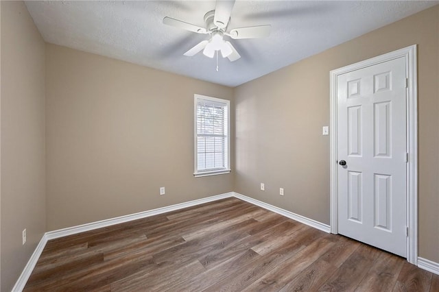 spare room featuring wood-type flooring, a textured ceiling, and ceiling fan