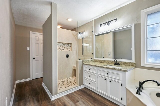 bathroom featuring hardwood / wood-style floors, vanity, shower with separate bathtub, and a textured ceiling