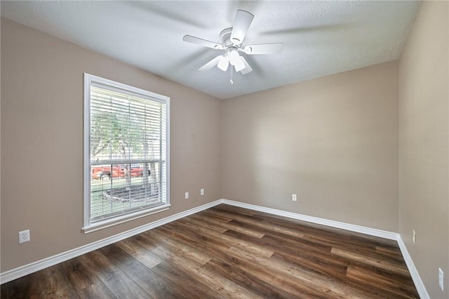 empty room with ceiling fan, dark hardwood / wood-style flooring, and a textured ceiling